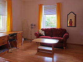 The large room with desk, sofa and small table
